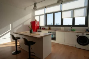 Cocina con isla y taburetes para organizar el catering y el descanso del equipo técnico