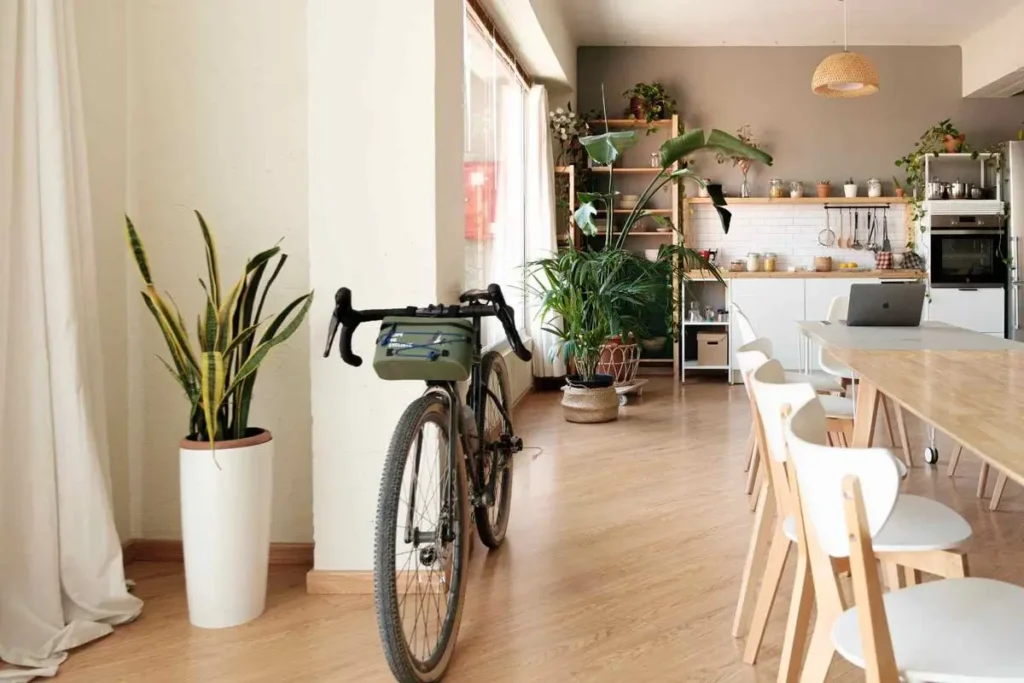Mesa larga de comedor con sillas de madera y plantas en un loft luminoso